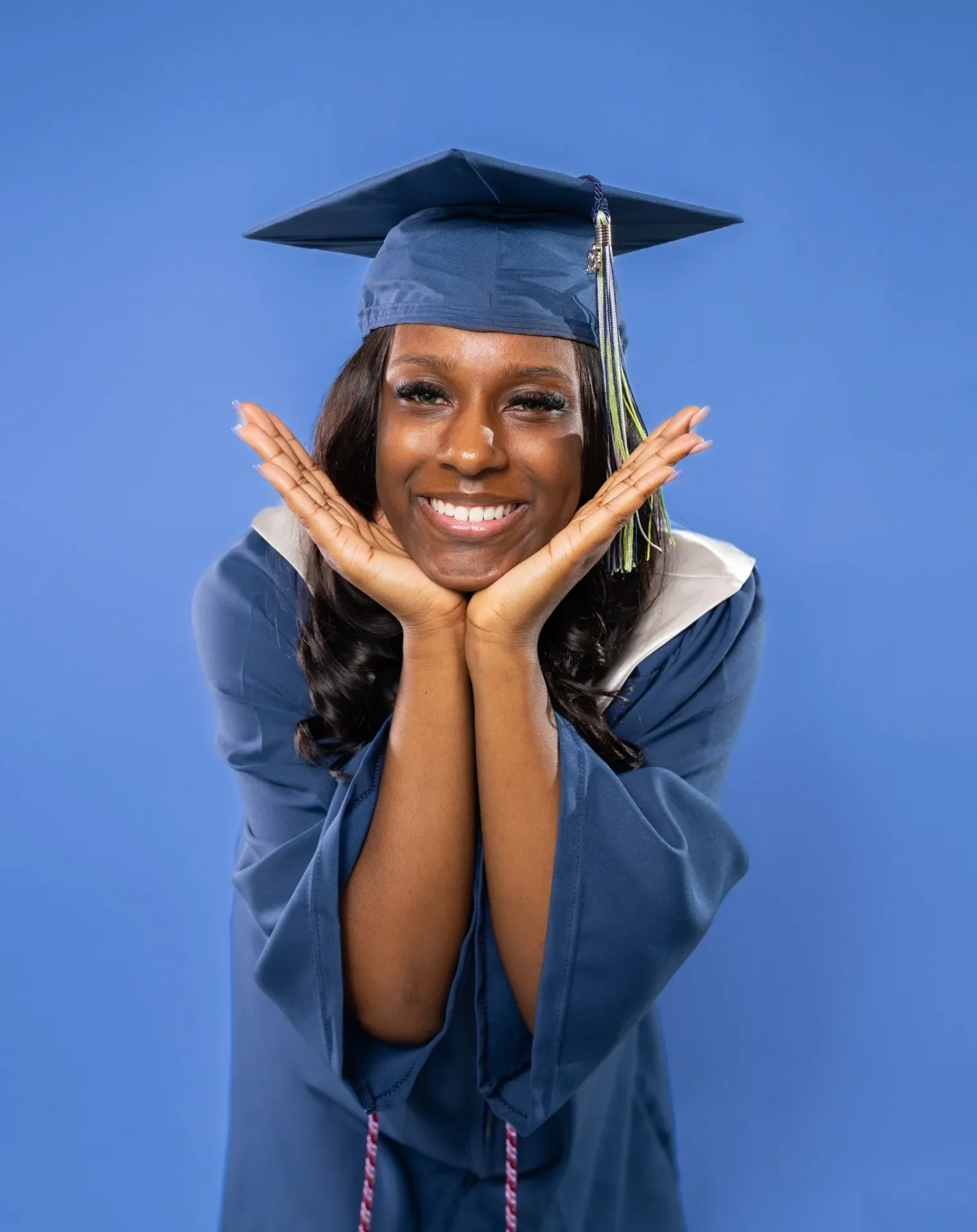 A woman in graduation gown and cap posing for the camera.