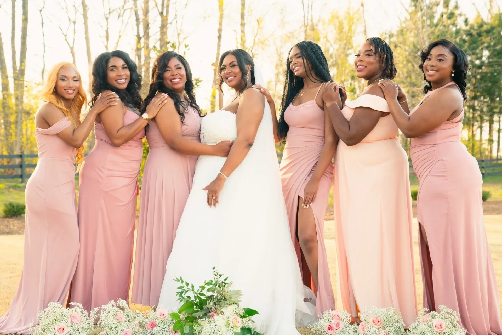 A group of women in pink dresses posing for the camera.