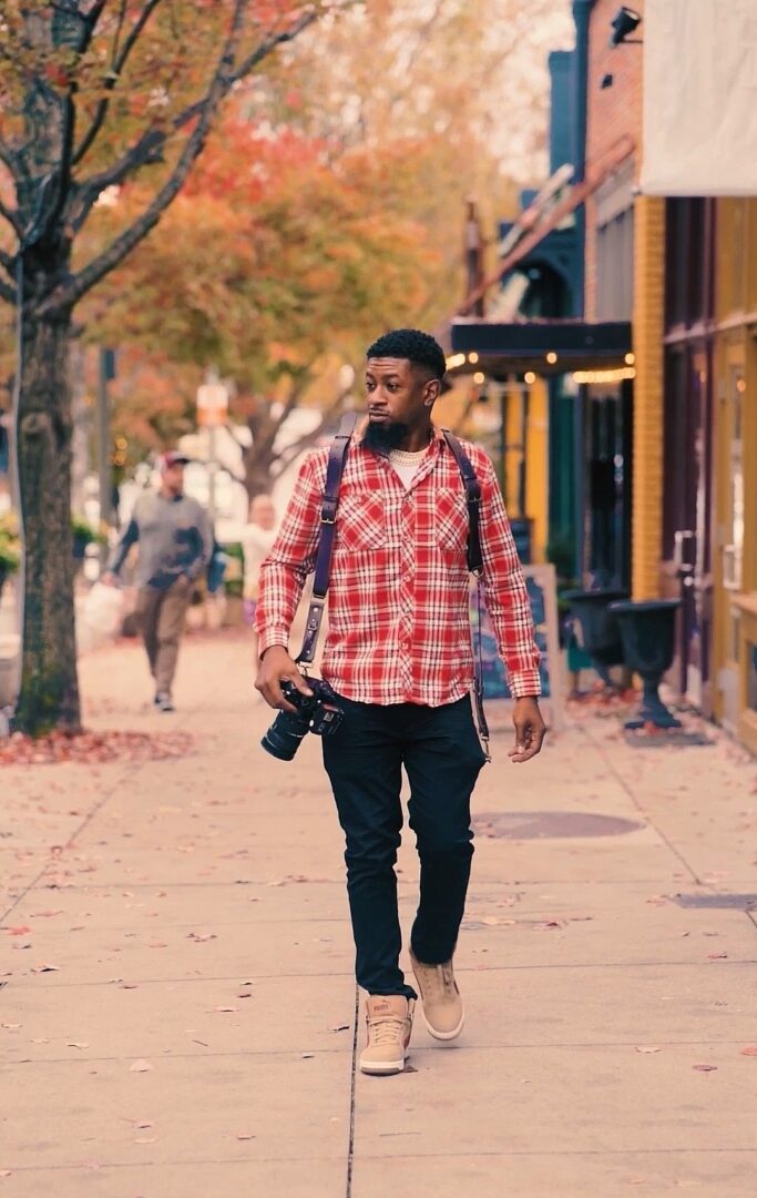 A man walking down the street with a camera.