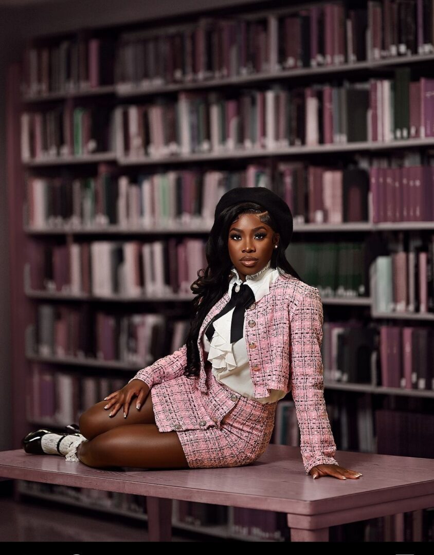 A woman in pink suit sitting on the floor.